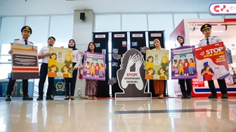 Petugas membawa poster kampanye anti kekerasan seksual di Stasiun BNI City, Jakarta, Selasa (21/4/2026). [Suara.com/Alfian Winanto]
