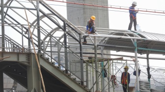 Kereta Rel Listrik (KRL) melintasi proyek pembangunan Stasiun Jakarta International Stadium (JIS) di kawasan Papanggo, Jakarta, Rabu (22/4/2026). [Suara.com/Alfian Winanto]
