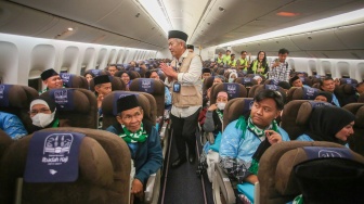 Wakil Direktur Utama Garuda Indonesia Thomas Sugiarto Oentoro (tengah) menyapa jamaah calon haji di dalam pesawat, di Terminal Haji dan Umrah 2F Bandara Soekarno Hatta, Tangerang, Banten, Rabu (22/4/2026). [ANTARA FOTO/Muhammad Iqbal/kye]