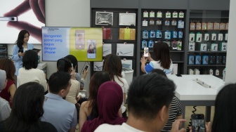 Pengunjung mencoba iphone saat gelaran Helloversary di Jakarta, Sabtu, (25/4/2026). [Suara.com/Alfian Winanto]