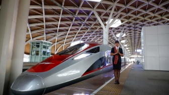 Pramugari menyapa penumpang di Stasiun Kereta Cepat Whoosh Halim, Jakarta Timur, Selasa (28/4/2026). [Suara.com/Alfian Winanto]