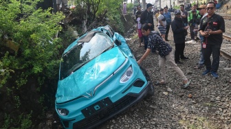 Warga mengamati taksi listrik Green SM yang rusak pascakecelakaan dengan KRL Commuter Line dan KA Argo Bromo Anggrek di Bekasi Timur, Bekasi, Jawa Barat, Selasa (28/4/2026). [ANTARA FOTO/Fakhri Hermansyah/nz]