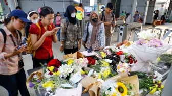 Warga berdoa di depan karangan bunga yang diletakkan di salah satu sudut Stasiun Bekasi Timur, Bekasi, Jawa Barat, Kamis (30/4/2026). [Suara.com/Alfian Winanto]
