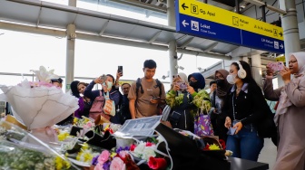 Warga berdoa di depan karangan bunga yang diletakkan di salah satu sudut Stasiun Bekasi Timur, Bekasi, Jawa Barat, Kamis (30/4/2026). [Suara.com/Alfian Winanto]