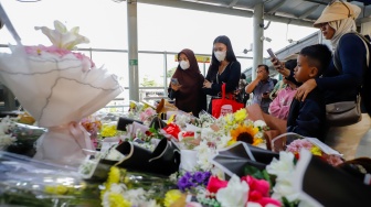 Warga berdoa di depan karangan bunga yang diletakkan di salah satu sudut Stasiun Bekasi Timur, Bekasi, Jawa Barat, Kamis (30/4/2026). [Suara.com/Alfian Winanto]
