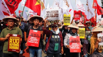 Massa dari berbagai elemen masyarakat dan buruh membawa poster pada aksi memperingati Hari Buruh Internasional atau May Day 2026 di depan gedung DPR RI, Jakarta, Jumat (1/5/2026). [Suara.com/Alfian Winanto]
