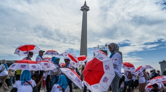 Massa buruh membawa payung mengikuti peringatan Hari Buruh Internasional atau May Day 2026 di kawasan Monumen Nasional (Monas), Jakarta, Jumat (1/5/2026). [ANTARA FOTO/Galih Pradipta/nz]