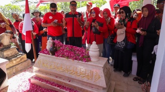 Sejumlah buruh memanjatkan doa di makam pahlawan nasional Marsinah di Desa Nglundo, Kabupaten Nganjuk, Jawa Timur, Jumat (1/5/2026). [ANTARA FOTO/Prasetia Fauzani/nz]