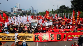 Massa dari berbagai elemen masyarakat dan buruh membawa poster pada aksi memperingati Hari Buruh Internasional atau May Day 2026 di depan gedung DPR RI, Jakarta, Jumat (1/5/2026). [Suara.com/Alfian Winanto]
