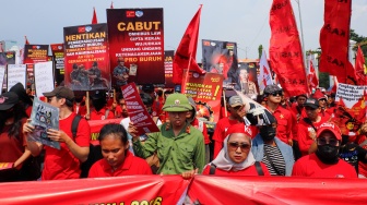 Massa dari berbagai elemen masyarakat dan buruh membawa poster pada aksi memperingati Hari Buruh Internasional atau May Day 2026 di depan gedung DPR RI, Jakarta, Jumat (1/5/2026). [Suara.com/Alfian Winanto]
