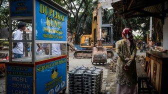 Warga menyaksikan petugas mengoperasikan alat berat saat pembongkaran bangunan liar di Pasar Kemis, Kabupaten Tangerang, Banten, Kamis (7/5/2026). [ANTARA FOTO/Putra M. Akbar/foc]