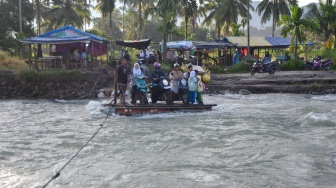 Enam Bulan Pascabencana, Warga Padang Pariaman Masih Sebrangi Sungai dengan Rakit