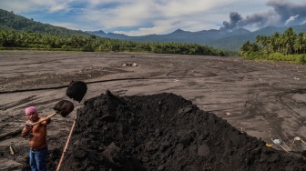 Warga menaikkan pasir ke atas truk di area bekas banjir lahar dingin di Desa Mamuya, Kecamatan Galela, Kabupaten Halmahera Utara, Maluku Utara, Selasa (12/5/2026). [ANTARA FOTO/Andri Saputra/sgd]