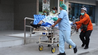 Sejumlah petugas mengevakuasi pasien saat terjadinya kebakaran di gedung Pusat Pelayanan Jantung Terpadu RSUD Dr Soetomo, Surabaya, Jawa Timur, Jumat (15/5/2026). [ANTARA FOTO/Didik Suhartono/hma]