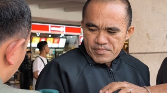 Petugas Kepolisian Bareskrim Mabes Polri memasangkan masker kepada AKP Deky Jonathan Sasiang setibanya dari Kaltim, di Terminal 2 Bandara Soekarno Hatta, Tangerang, Banten, Senin (18/5/2026). [ANTARA FOTO/Muhammad Iqbal/kye]

