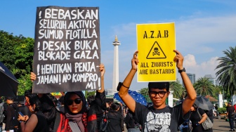 Relawan dari berbagai elemen memajang plakat tulisan dan poster dalam aksi solidaritas bagi WNI dan jurnalis yang diculik Israel di Jakarta, Kamis (21/5/2026). [Suara.com/Alfian Winanto]
