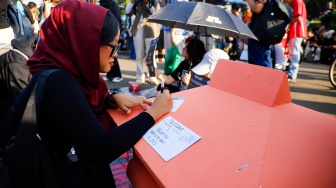 Pegiat HAM yang tergabung dalam Jaringan Solidaritas Korban menulis pesan perubahan saat mengikuti aksi kamisan ke-908 di seberang Istana Merdeka, Jakarta, Kamis (21/5/2026). [Suara.com/Alfian Winanto]
