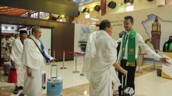Petugas Imigrasi Kerajaan Arab Saudi menyambut kedatangan jamaah calon haji Indonesia kloter terakhir di Makkah Route di Terminal Khusus Haji dan Umrah 2 F, Bandara Soekarno Hatta, Tangerang, Banten, Kamis (21/5/2025). [ANTARA FOTO/Muhammad Iqbal/foc]