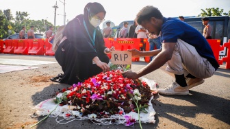 Pegiat HAM yang tergabung dalam Jaringan Solidaritas Korban untuk Keadilan menaburkan bunga saat aksi kamisan ke-908 di seberang Istana Merdeka, Jakarta, Kamis (21/5/2026). [Suara.com/Alfian Winanto]
