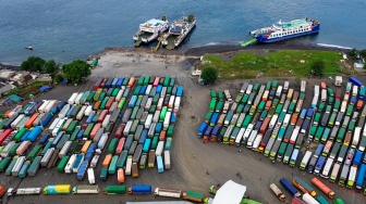 Foto udara kendaraan angkutan barang antre di kantong parkir sebelum menyeberang ke Bali di Dermaga Bulusan, Ketapang, Banyuwangi, Jawa Timur, Kamis (21/5/2026).  [ANTARA FOTO/Budi Candra Setya/YU]