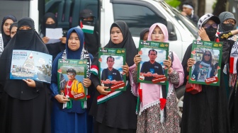 Massa yang berasal dari Aliansi kemanusiaan Aqsa Working Group (AWG) membawa poster bertema penculikan aktivis oleh zionis saat Aksi Jumat untuk Palestina di depan Kedutaan Besar Amerika Serikat, Jakarta, Jumat (22/5/2026). [Suara.com/Alfian Winanto]