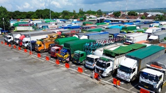 Foto udara kendaraan angkutan barang yang akan menyeberang ke Bali antre di kantong parkir Dermaga Bulusan, Ketapang, Banyuwangi, Jawa Timur, Jumat (22/5/2026). [ANTARA FOTO/Budi Candra Setya/YU]