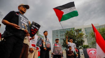Massa yang berasal dari Aliansi kemanusiaan Aqsa Working Group (AWG) membawa poster bertema penculikan aktivis oleh zionis saat Aksi Jumat untuk Palestina di depan Kedutaan Besar Amerika Serikat, Jakarta, Jumat (22/5/2026). [Suara.com/Alfian Winanto]