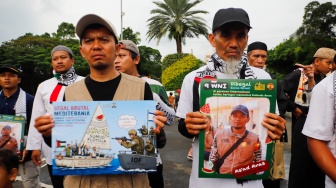 Massa yang berasal dari Aliansi kemanusiaan Aqsa Working Group (AWG) membawa poster bertema penculikan aktivis oleh zionis saat Aksi Jumat untuk Palestina di depan Kedutaan Besar Amerika Serikat, Jakarta, Jumat (22/5/2026). [Suara.com/Alfian Winanto]