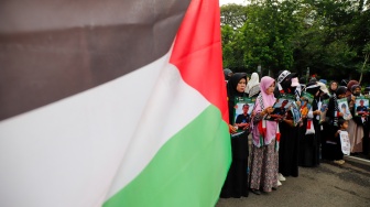 Massa yang berasal dari Aliansi kemanusiaan Aqsa Working Group (AWG) membawa poster bertema penculikan aktivis oleh zionis saat Aksi Jumat untuk Palestina di depan Kedutaan Besar Amerika Serikat, Jakarta, Jumat (22/5/2026). [Suara.com/Alfian Winanto]