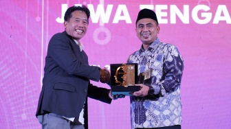 Editor In Chief Suara.com Suwarjono (kiri) memberikan plakat kepada Wakil Gubernur Jawa Tengah Taj Yasin Maimoen (kanan) dalam gelaran Jateng Media Summit 2026 di Semarang, Jawa Tengah, Kamis (21/5/2026). [Dok Jateng Media Summit] 
