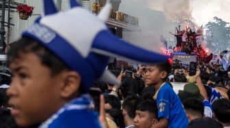 Warga menyalakan suar saat pawai Juara Pancatakhta di Jalan Asia Afrika, Bandung, Jawa Barat, Minggu (24/5/2026). [ANTARA FOTO/Abdan Syakura/nym.]