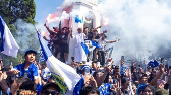 Warga menyalakan suar saat menyaksikan konvoi Persib Bandung juara BRI Super League 2025-2026 di Bandung, Jawa Barat, Minggu (24/5/2026). [ANTARA FOTO/Abdan Syakura/nym.] 