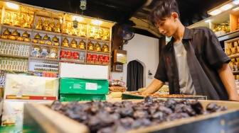 Penjual oleh-oleh haji dan umroh melayani calon pembeli kurma di Pasar Tanah Abang, Jakarta, Senin (25/5/2026). [Suara.com/Alfian Winanto]
