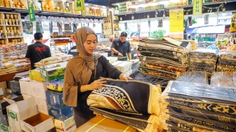 Penjual oleh-oleh haji dan umroh melayani calon pembeli kurma di Pasar Tanah Abang, Jakarta, Senin (25/5/2026). [Suara.com/Alfian Winanto]
