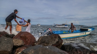 Warga mengangkut barang ke dalam perahu motor yang bersandar di tepi bebatuan Pantai Labuha, Pulau Bacan, Kabupaten Halmahera Selatan, Maluku Utara, Selasa (26/5/2026). [ANTARA FOTO/Andri Saputra/agr]