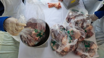 Petugas membagi daging hewan kurban kedalam plastik di Masjid Sunda Kelapa, Jakarta, Rabu (27/5/2026). [Suara.com/Alfian Winanto]