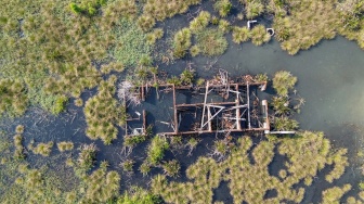 Foto udara sebuah rumah rusak di pinggir kolam penampungan semburan lumpur Lapindo di Porong, Sidoarjo, Jawa Timur, Jumat (29/5/2026). [ANTARA FOTO/Umarul Faruq/nz]