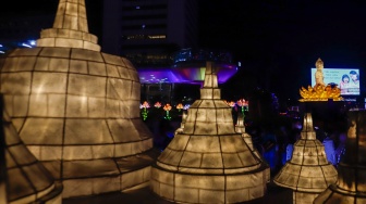 Warga melihat ornamen lampu hias saat llumination of Jakarta: Glow of Peace di kawasan Bundaran HI, Jakarta, Jumat (29/5/2026). [Suara.com/Alfian Winanto]