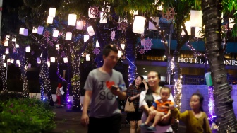 Warga melihat ornamen lampu hias saat llumination of Jakarta: Glow of Peace di kawasan Bundaran HI, Jakarta, Jumat (29/5/2026). [Suara.com/Alfian Winanto]