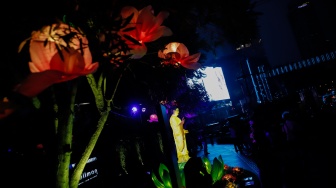Warga melihat ornamen lampu hias saat llumination of Jakarta: Glow of Peace di kawasan Bundaran HI, Jakarta, Jumat (29/5/2026). [Suara.com/Alfian Winanto]
