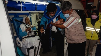 Petugas membantu seorang haji lansia turun dari ambulans setibanya di Asrama Haji Batam, Kepulauan Riau, Senin(1/6/2026). [ANTARA FOTO/Teguh Prihatna/kye]