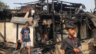 Warga mencari barang di rumahnya yang telah terbakar di kawasan Kebon Kosong, Kemayoran, Jakarta, Selasa (2/6/2026). [Suara.com/Alfian Winanto]
