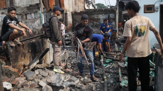 Warga mencari barang di rumahnya yang telah terbakar di kawasan Kebon Kosong, Kemayoran, Jakarta, Selasa (2/6/2026). [Suara.com/Alfian Winanto]
