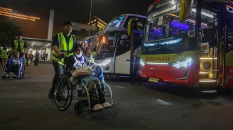 Petugas membantu jamaah haji kloter pertama asal DKI Jakarta menuju bus saat tiba di Terminal 2 F Khusus Haji dan Umrah Bandara Soekarno Hatta, Tangerang, Banten, Senin (1/6/2026). [ANTARA FOTO/Muhammad Iqbal/kye]
