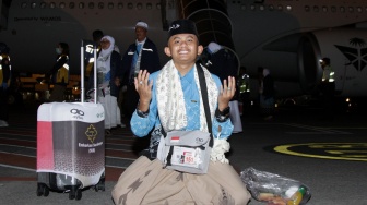 Seorang haji dari kelompok terbang (kloter) pertama memanjatkan doa syukur saat tiba di Bandara Internasional Juanda, Sidoarjo, Jawa Timur, Senin (1/6/2026). [ANTARA FOTO/Umarul Faruq/kye]