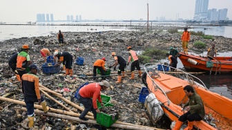 Foto udara petugas mengangkut sampah yang mengendap di perairan laut Jakarta, Rabu (3/6/2026). [ANTARA FOTO/Sulthony Hasanuddin/nz]