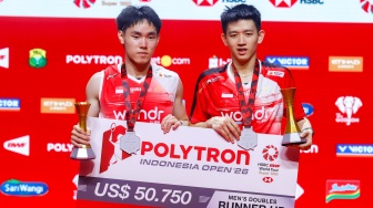 Pebulu tangkis ganda putra Indonesia Raymond Indra/Nikolaus Joaquin berpose dengan pialanya usai dikalahkan ganda putra Malaysia Goh Sze Fei/Nur Izzuddin pada final Polytron Indonesia Open 2026 di Istora Senayan, Jakarta, Minggu (7/6/2026). [Suara.com/Alfian Winanto]