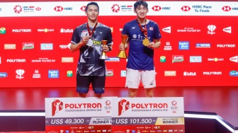 Pebulu tangkis tunggal putra Indonesia Jonatan Christie (kiri) dan tunggal putra Kanada Victor Lai (kanan) berpose dengan pialanya usai pertandingan final Polytron Indonesia Open 2026 di Istora Senayan, Jakarta, Minggu (7/6/2026). [Suara.com/Alfian Winanto]