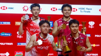 Pebulu tangkis ganda putra Indonesia Raymond Indra/Nikolaus Joaquin (kiri) dan ganda putra Malaysia Goh Sze Fei/Nur Izzuddin (kanan) berpose dengan pialanya usai pertandingan final Polytron Indonesia Open 2026 di Istora Senayan, Jakarta, Minggu (7/6/2026). [Suara.com/Alfian Winanto]