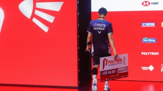 Pebulu tangkis tunggal putra Indonesia Jonatan Christie berjalan kebalik panggung podium dengan pialanya usai dikalahkan Pebulu Tangkis tunggal putra Kanada Victor Lai pada pertandingan final Polytron Indonesia Open 2026 di Istora Senayan, Jakarta, Minggu (7/6/2026). [Suara.com/Alfian Winanto]
